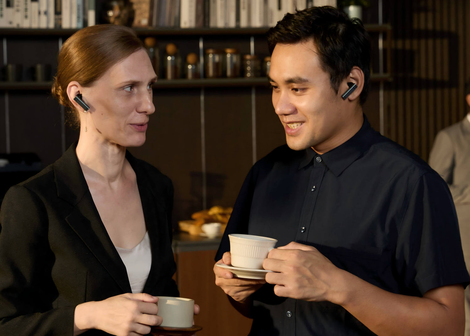 두 사람이 X1 Meeting 이어버드로 1:1 양방향 동시통역 대화를 나누는 장면